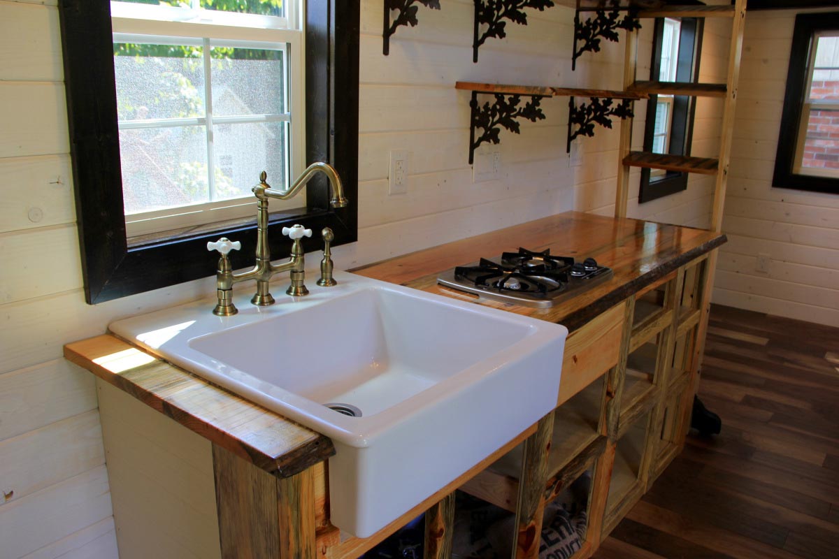 Kitchen area features open faced cabinets - Fort Austin by Brevard Tiny House