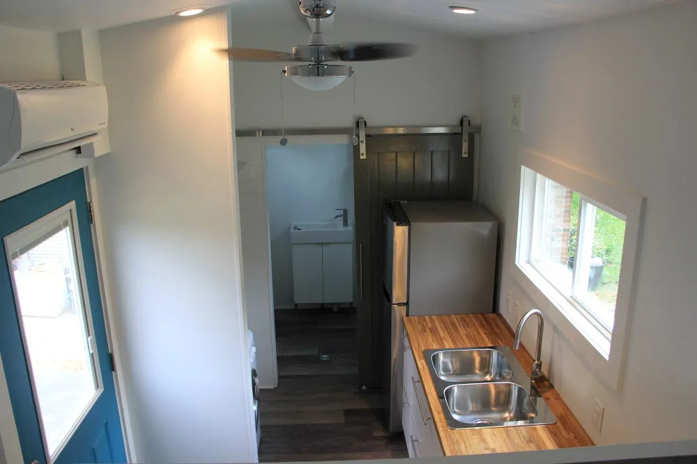 Kitchen with full refrigerator and double sink - Every Tiny Moment by Brevard Tiny House