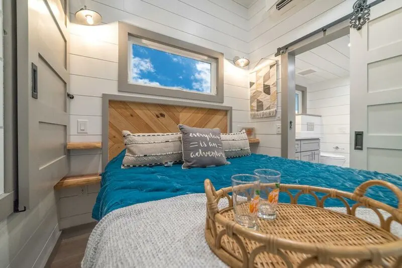 Rustic tiny house has a spacious interior and a balcony up top