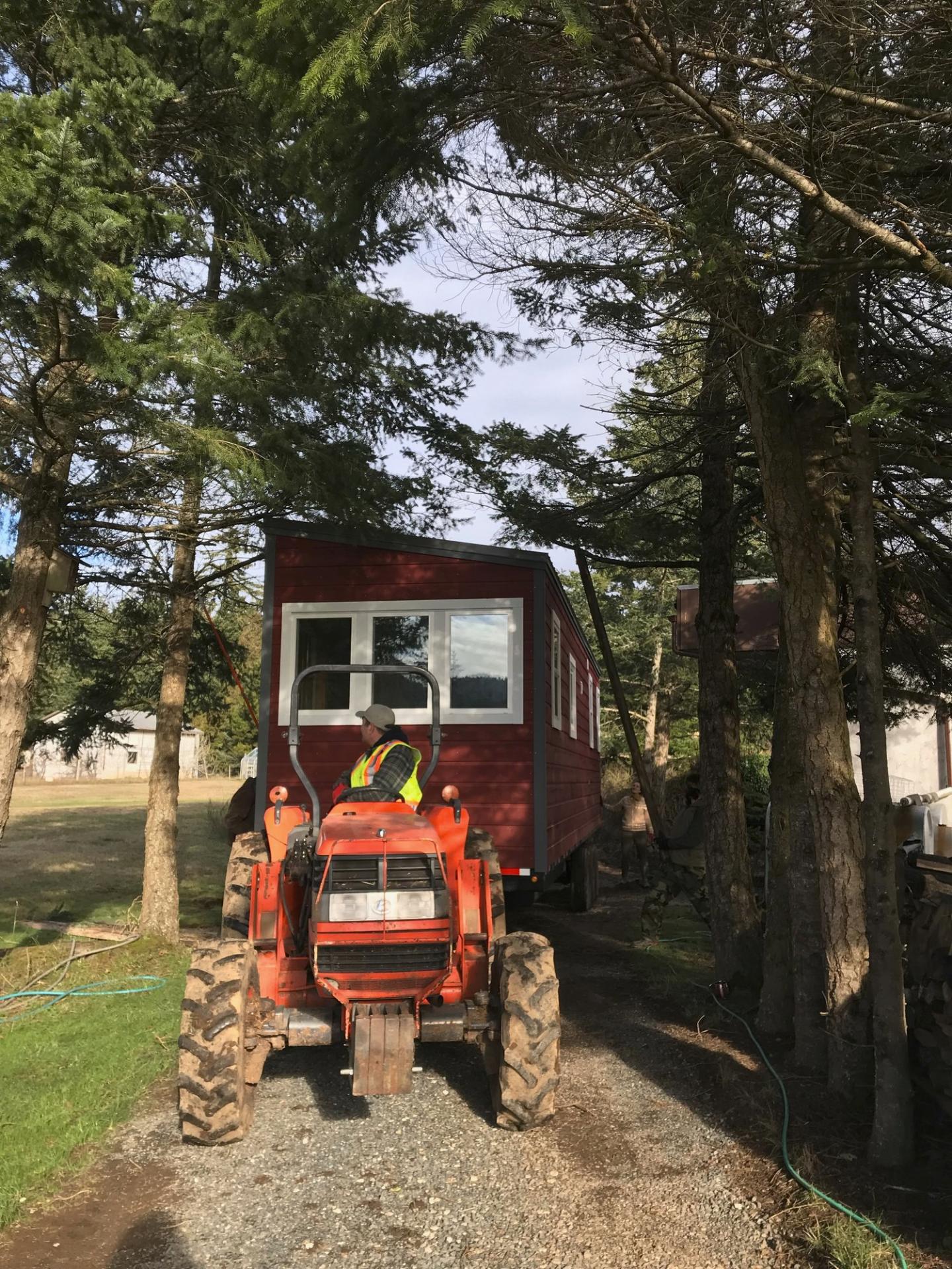 Tiny House Being Towed by Tractor - Big Red by Rewild Homes