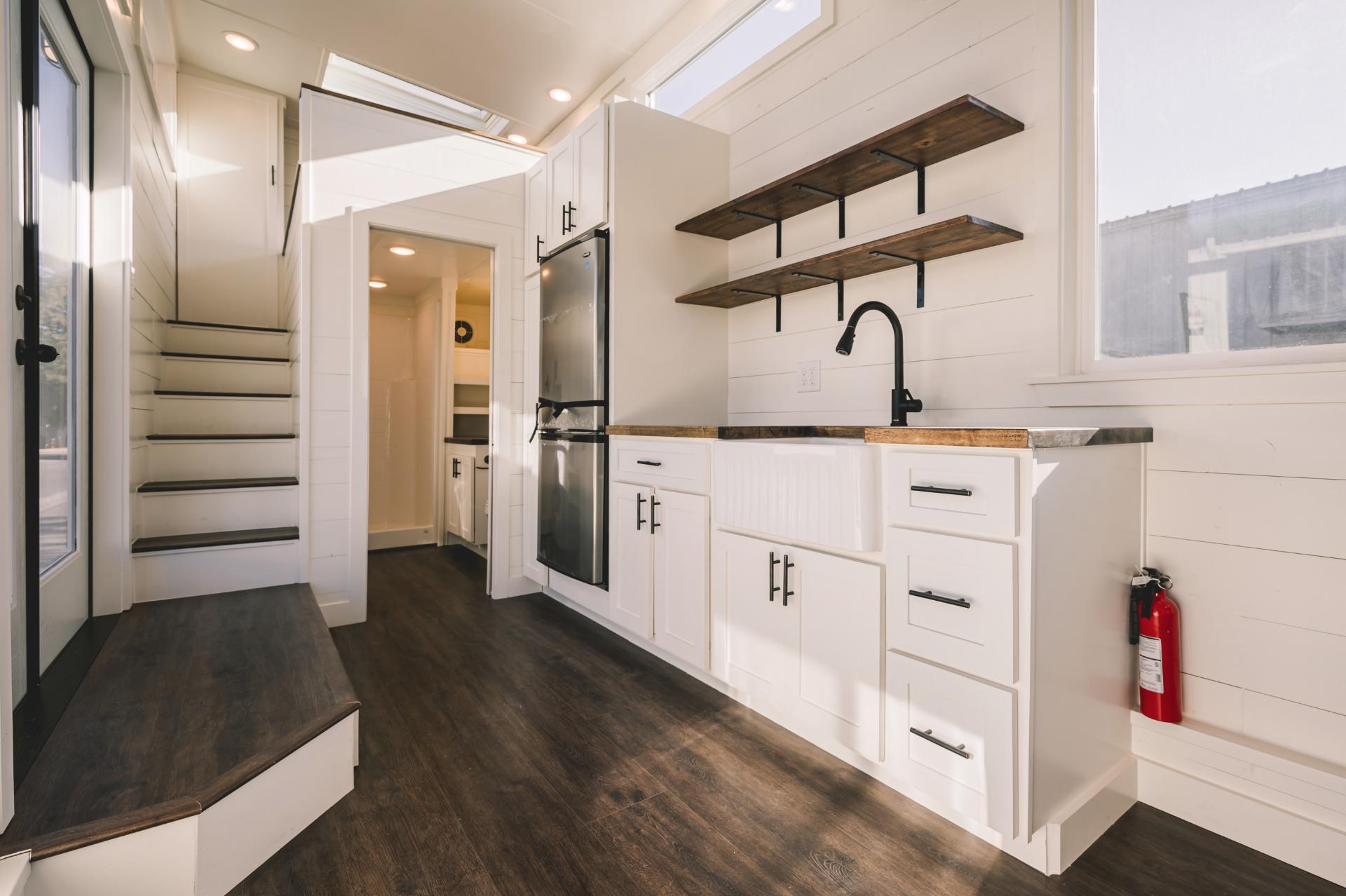Kitchen with White Cabinets and Stained Wood Shelves - Gallery 30 by California Tiny House