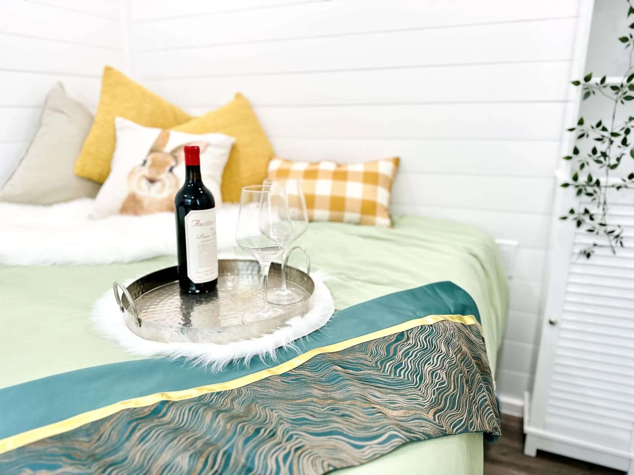 Tray with Wine on Bed with Green Bedding - Avalon by Dragon Tiny Homes