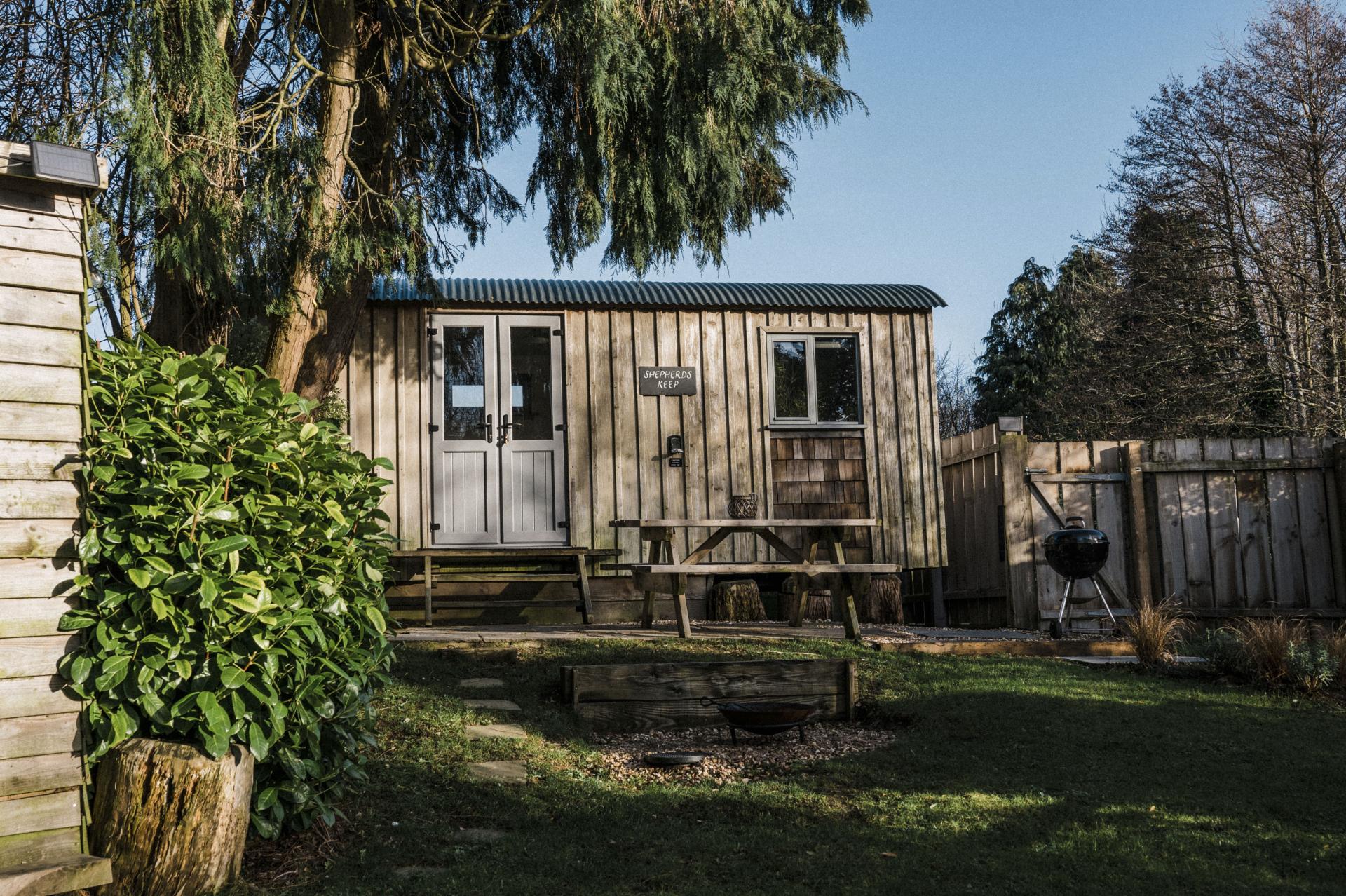 Exterior View of Tiny House with Picnic Table - Shepherds Keep at The Shepherds Hut Retreat